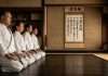 Dojo Kun: El código ético del Karate que transforma el carácter más allá del tatami Practicantes de Karate en posición seiza recitando el Dojo Kun en un dojo tradicional.