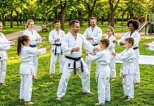 El “bajón” de verano: Estrategias clave para que tu dojo no se vacíe durante las vacaciones Clase de karate al aire libre integrada por padres e hijos durante las vacaciones de verano.